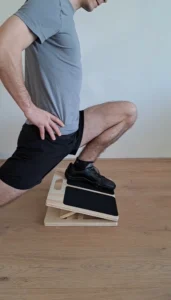 an athlete doing a split squat on the slant board