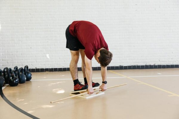An athlete doing a mobility exercise on a slant board