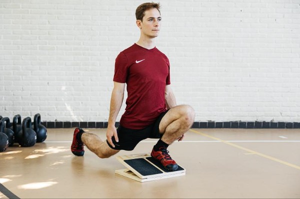 a demonstration of a slant board knees over toes for beginners squat